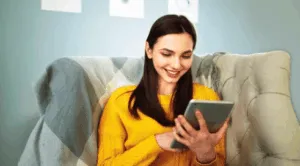 Donna sorridente usa tablet sul divano