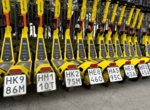 Fila di monopattini elettrici gialli parcheggiati in città